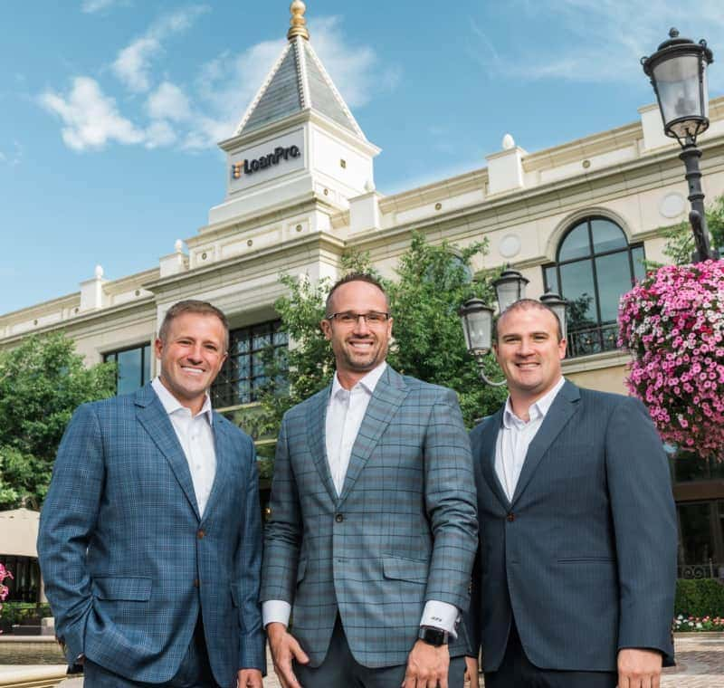 Roberts brothers standing in a group with the office in the background